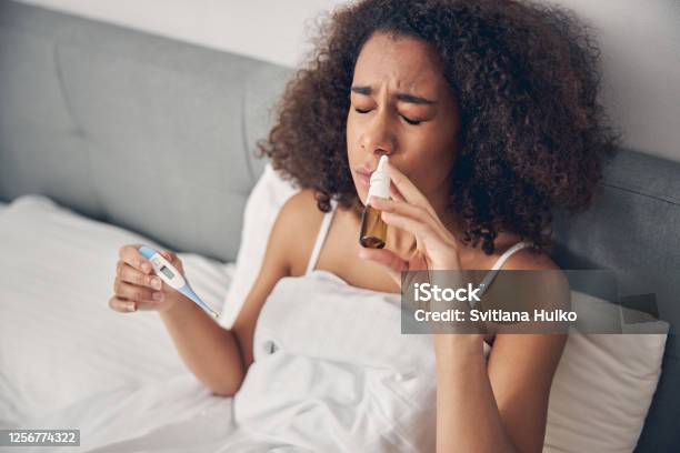 Upset Ill Lady Holding A Digital Thermometer In Her Hand Stock Photo - Download Image Now