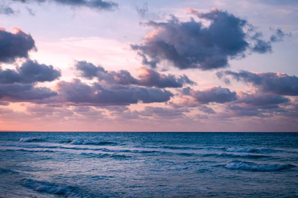 istock image of purple dramatic sky at sunset with clouds over sea. 1256776701