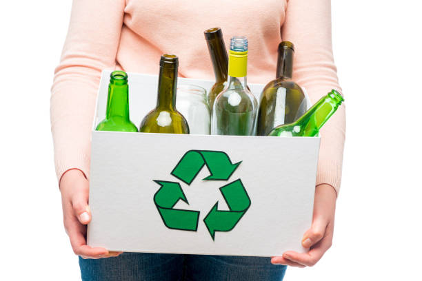 istock Female holding waste glass in recycling bin 1256776875