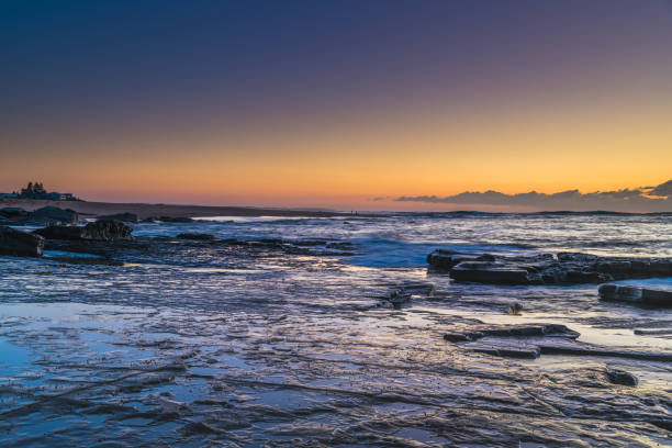 istock Sunrise seascape with a low cloud bank from rock platform 1256779311