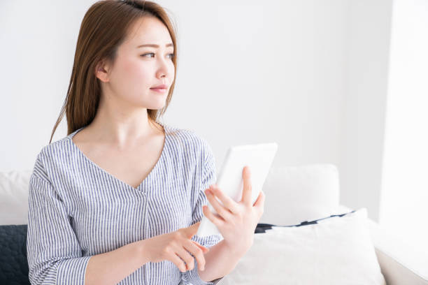 istock asian woman to see a tablet computer 1256779967