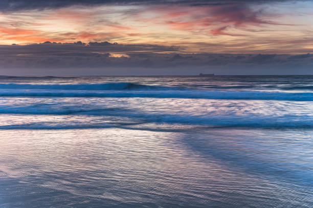 istock Sunrise Seascape with Clouds and Ships on the Horizon 1256780077