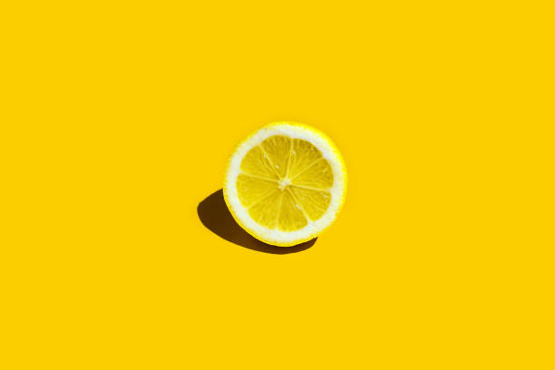 istock Juicy slice of lemon on yellow background 1256780294