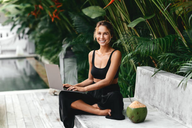 mujer trabaja como freelance escribiendo en el ordenador portátil con coco fresco. - swimwear bikini swimming pool red fotografías e imágenes de stock
