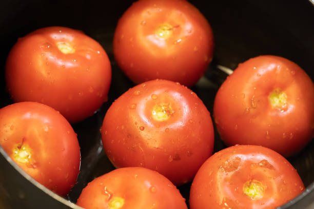 istock Close-up of tomatoes in a black pot 1256789148