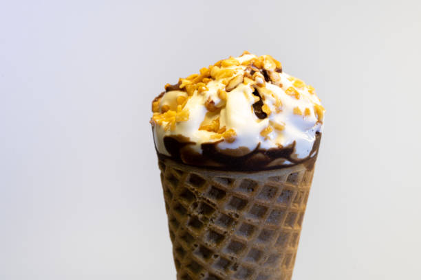 istock Vanilla ice cream cone topped with peanuts and chocolate 1256789224