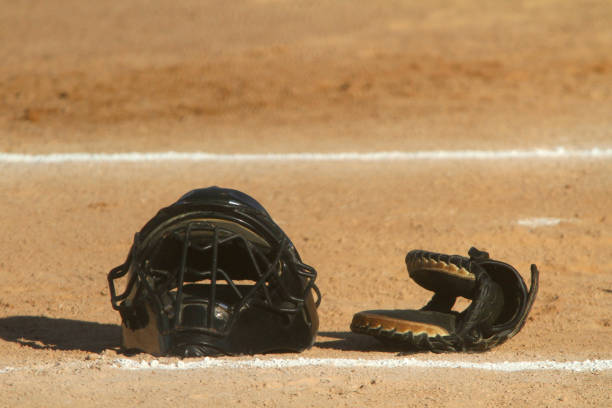 Catcher's Mask and Glove A catcher's mask and glove sit in the infield dirt near home plate in an image with room for copy in the upper portion of the frame. catchers mask stock pictures, royalty-free photos & images