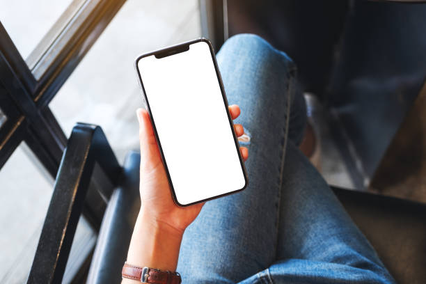 istock a woman holding mobile phone with blank white desktop screen 1256802535