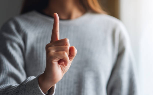 istock a woman making and showing number one hand sign 1256802771