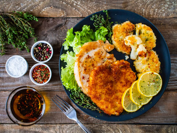 木製テーブルに焼きポークチョップと野菜サラダ - schnitzel cutlet food meal ストックフォトと画像