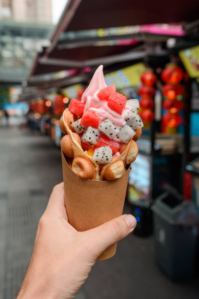 istock Egg waffle cone with fruits in hand 1256808344