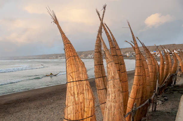 пляж уанчако и традиционные камышовые лодки (caballitos de totora) - трухильо, перу - huanchaco стоковые фото и изображения