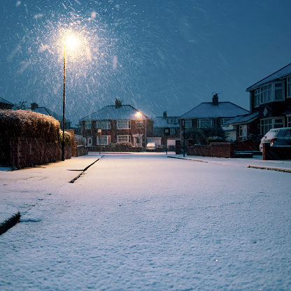 Fresh snow is covering the road and homes in a residential area of England