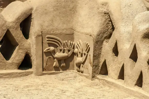 Detail of an adobe wall with a animal ssymbol design in the Chan Chan pre-hispanic citadel, near Trujillo, Peru.