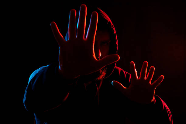 istock a man on a dark background from different sides lit in different colors in blue and red 1256815665