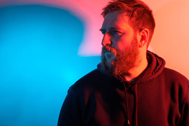 istock bearded white man on a contrasting multi-colored background blue and red 1256815669