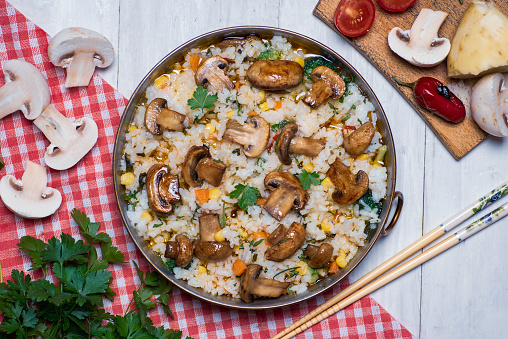 Homemade vegetarian risotto with mushrooms and vegetables on a plate tabletop flat lay