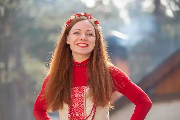 Russian girl in national clothes. Belarussian woman in a wreath with a smile. Ukrainian beauty in ethnic costume.