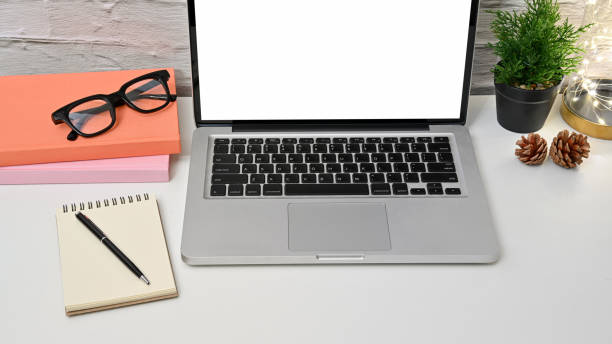 istock Cropped shot view of modern workspace with blank screen laptop 1256818537