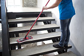 Woman washes stairway at house. Cleaning service concept.