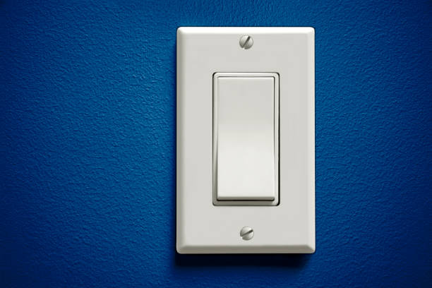Light switch Image of a single light switch on a blue wall light switch photos stock pictures, royalty-free photos & images