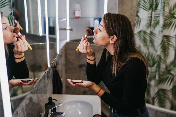 istock Young woman applying make up 1256832163