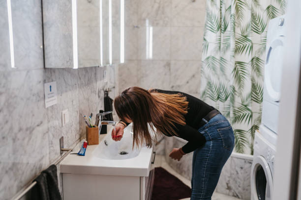 istock Woman washes face in bathroom 1256832191