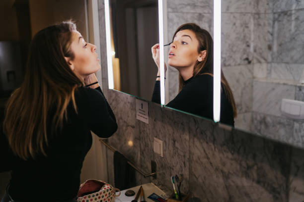 istock Young woman applying make up 1256832283