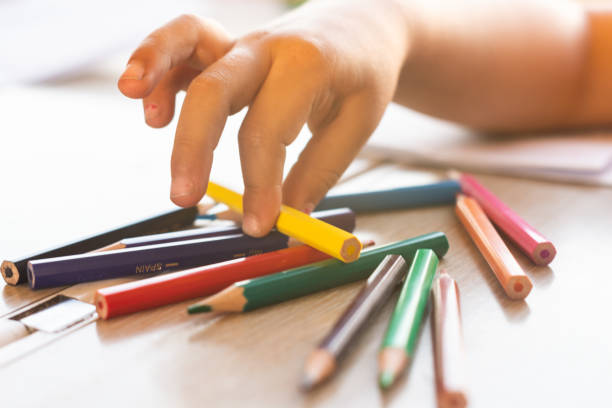 istock Girl's hand picking colors to paint on a train 1256834981