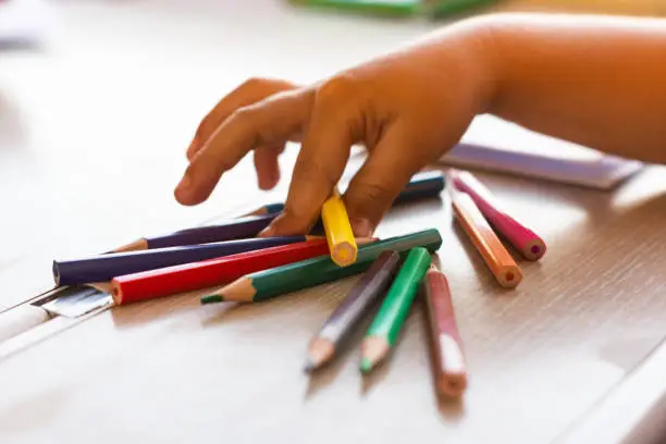 Photo of Girl's hand picking colors to paint on a train