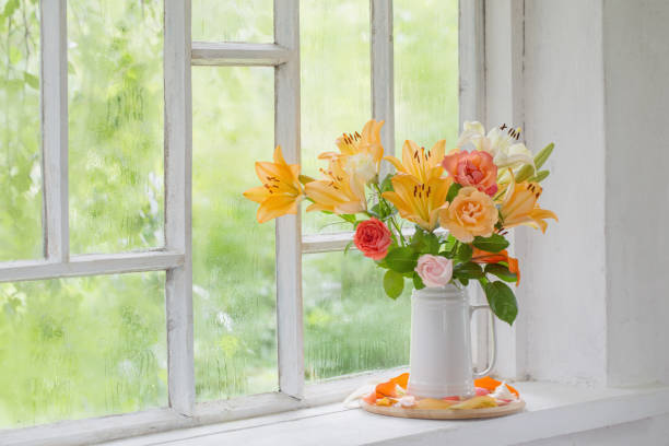 istock summer flowers in vase on background window with drops water 1256835834