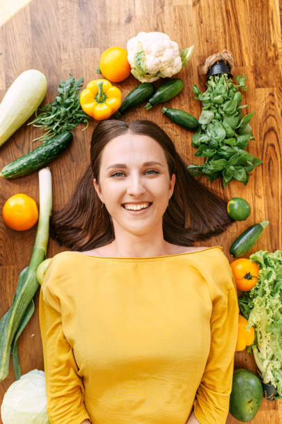 istock A woman lies surrounded with fresh vegetables 1256836152