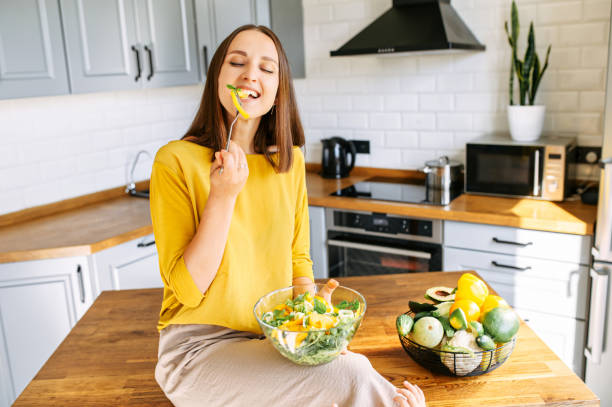 istock An attractive woman eats fresh salad 1256836174