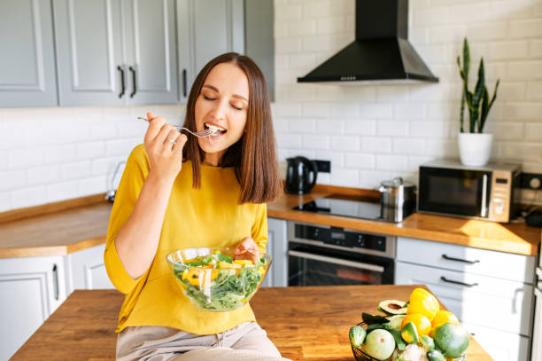 istock An attractive woman eats fresh salad 1256836178