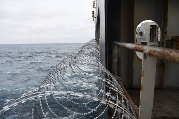 西アフリカのギニア湾での海賊行為攻撃から乗組員を保護するために船体、上部構造と手すりに取り付けられた有刺鉄線。 - benin ストックフォトと画像