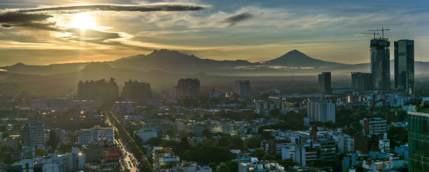 Sunset over Mexico City Eje 8 Sur Avenue, by Col. Acacias, Del Valle Sur districts and neighborhoods, south side of Mexico City, CDMX, Mexico. Two volcanoes in the sunrise background. popocatepetl volcano photos stock pictures, royalty-free photos & images