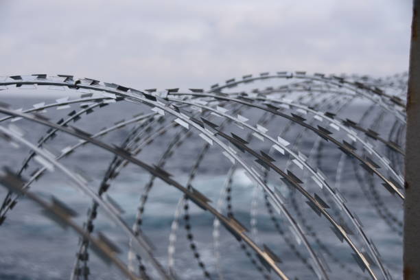 detalle del alambre de púas unido al casco del barco, la superestructura y las barandillas para proteger a la tripulación contra el ataque a la piratería en el golfo de guinea, en el oeste de africa. - winter wire barbed wire protection fotografías e imágenes de stock