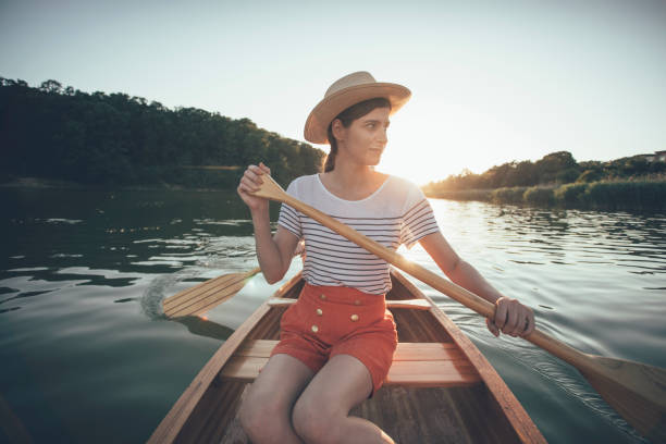 istock Young woman paddling canoe 1256840418