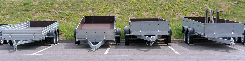 open empty trailers for car cargo truck stands in row outside on parking lot for vehicle rent and sale transport concept