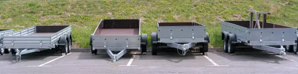 open empty trailers for car cargo truck stands in row outside on parking lot for vehicle rent and sale transport concept