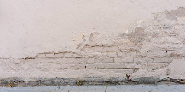 широкая кирпичная белая стена с заброшенным старым гипсовым фоном - sign dirty plaster red стоковые фото и изображения