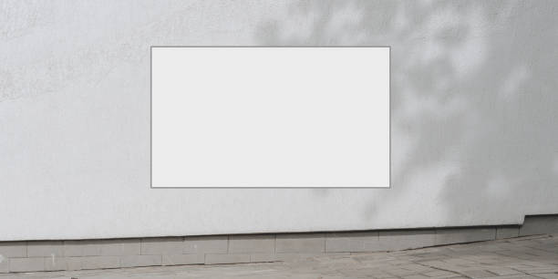 istock empty sign with mock-up white colour hanging on concrete building wall with shadow over sidewalk at city street commercial advertising concept 1256841769