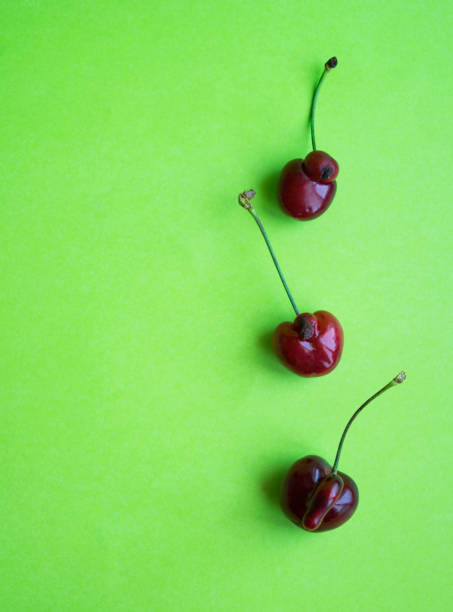 istock Layout of sweet cherries on a green background. 1256842608