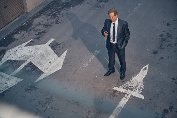 istock Well-dressed businessman using cellphone on the street 1256842785