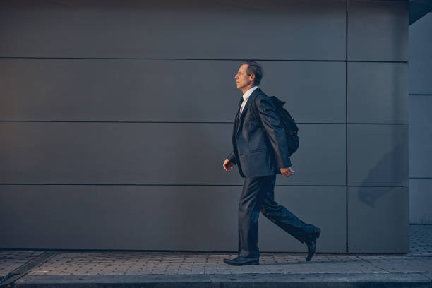 istock Handsome man with backpack walking on the street 1256842788