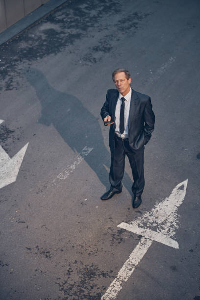 istock Good-looking man in suit using smartphone on the street 1256842795