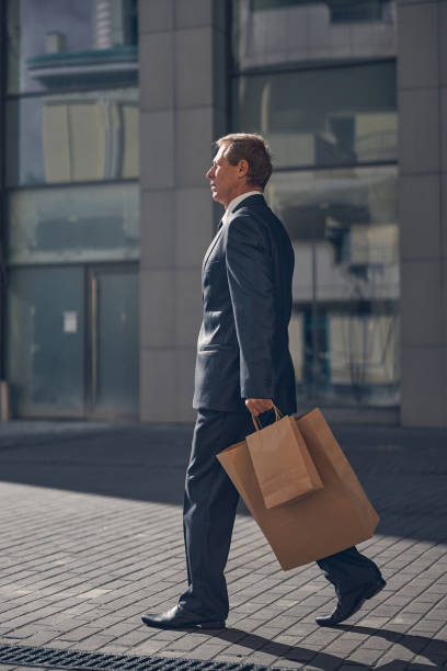 istock Handsome man in suit walking on the street 1256842831