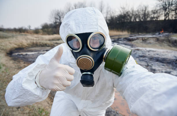 istock Scientist exploring the territory, emission area, polluted water, man in protective suit installing warning signs 1256843804