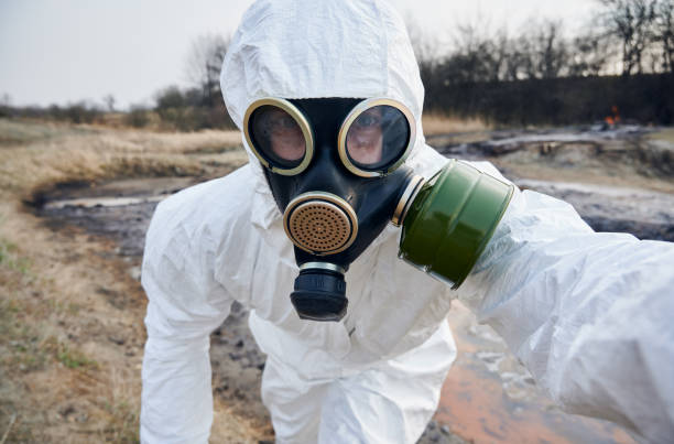 istock Scientist exploring the territory, emission area, polluted water, man in protective suit installing warning signs 1256843807