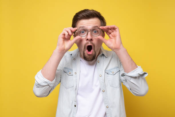 istock Man looking through glasses looking into the distance being shocked. 1256845015